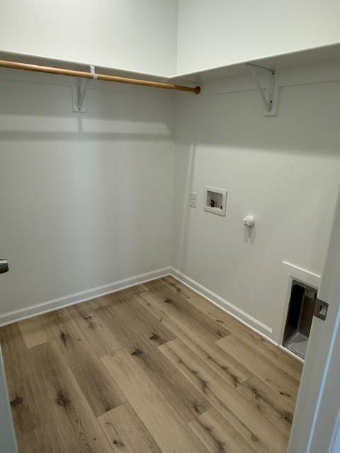 washroom featuring washer hookup, laundry area, baseboards, and wood finished floors