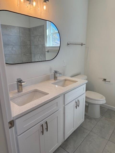 bathroom with double vanity, a sink, and toilet