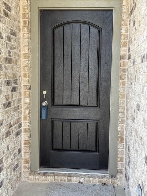 doorway to property with brick siding