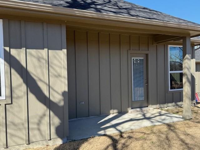 entrance to property featuring a shingled roof and board and batten siding