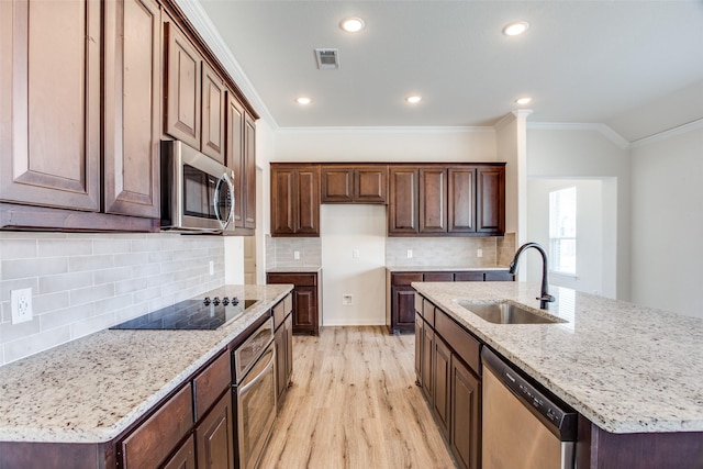 kitchen with appliances with stainless steel finishes, visible vents, a sink, and crown molding