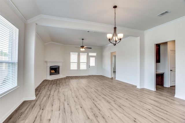 unfurnished living room with a healthy amount of sunlight, visible vents, a fireplace with raised hearth, and light wood-style flooring