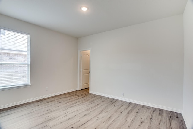 spare room featuring recessed lighting, light wood finished floors, and baseboards