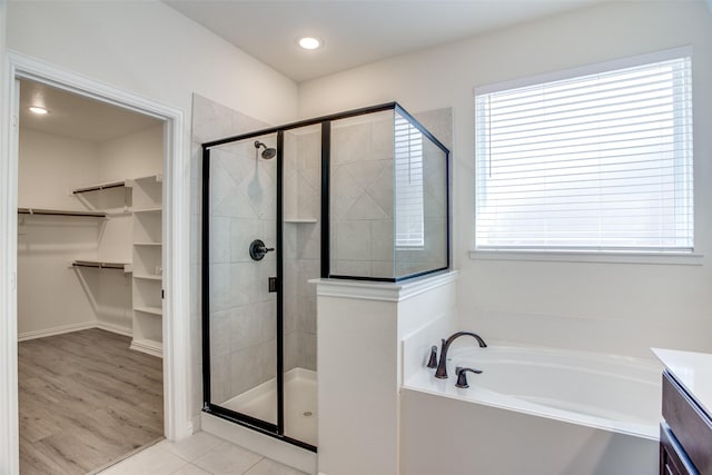 bathroom featuring a spacious closet, vanity, a shower stall, tile patterned flooring, and a bath