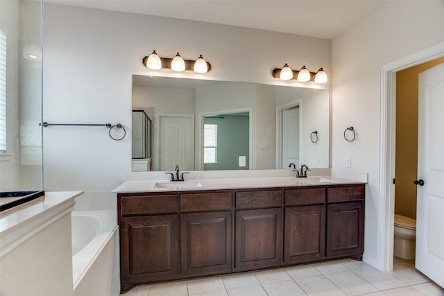 bathroom featuring a garden tub, double vanity, and a sink