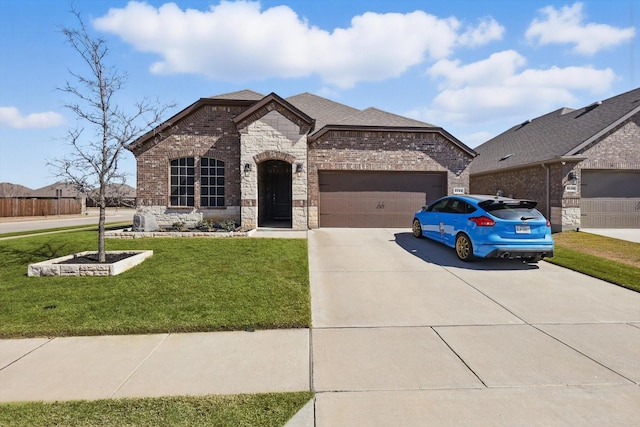 french country inspired facade featuring driveway, stone siding, an attached garage, a front lawn, and brick siding