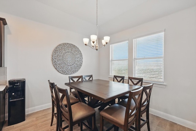 dining space featuring a notable chandelier, light wood-type flooring, and baseboards