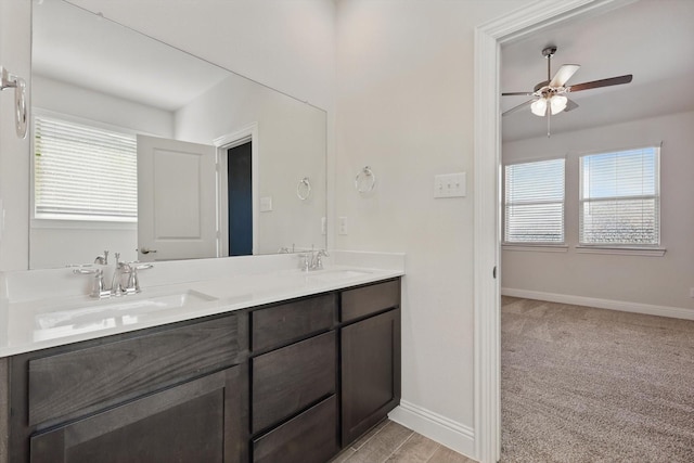 bathroom with a healthy amount of sunlight, baseboards, and a sink