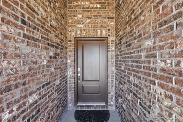 view of exterior entry with brick siding