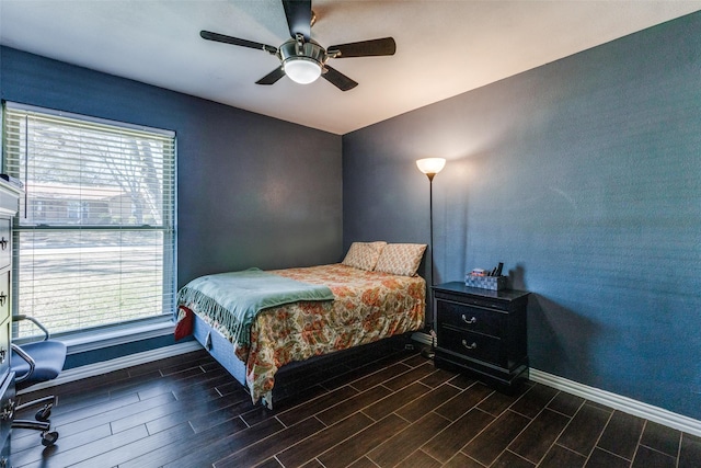 bedroom with a ceiling fan, wood finish floors, and baseboards