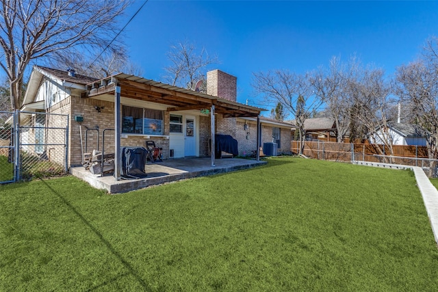 back of property with central AC, a lawn, a chimney, and a fenced backyard