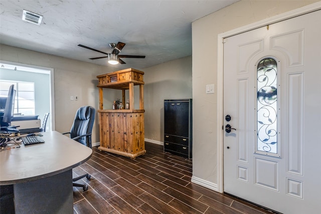 office space featuring a ceiling fan, wood tiled floor, visible vents, and baseboards