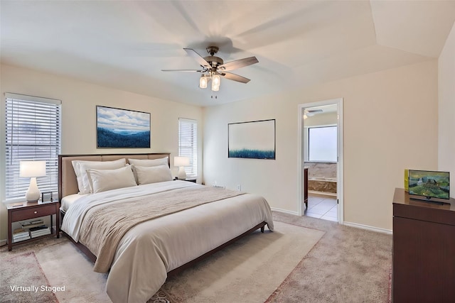 bedroom featuring a ceiling fan, light carpet, connected bathroom, and baseboards