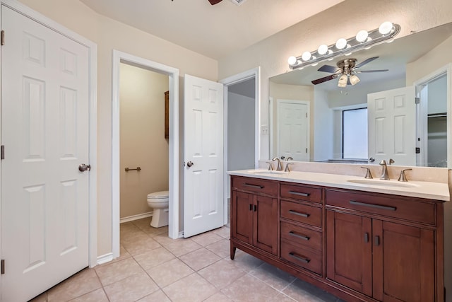 full bath featuring toilet, tile patterned flooring, ceiling fan, and a sink