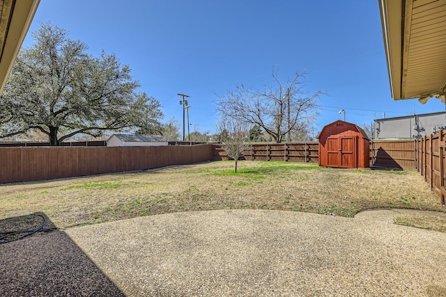 view of yard with an outbuilding, a storage unit, a patio area, and a fenced backyard