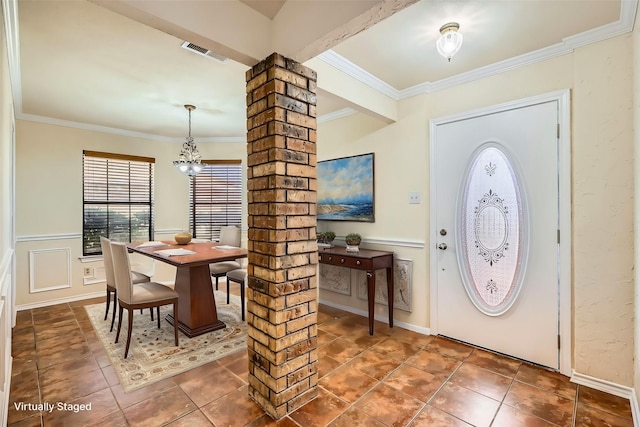 entryway featuring tile patterned flooring, visible vents, wainscoting, ornate columns, and crown molding