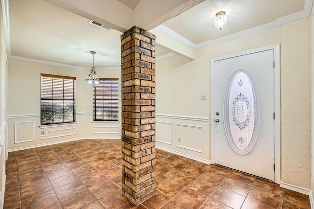 entryway featuring a decorative wall, visible vents, ornamental molding, wainscoting, and decorative columns