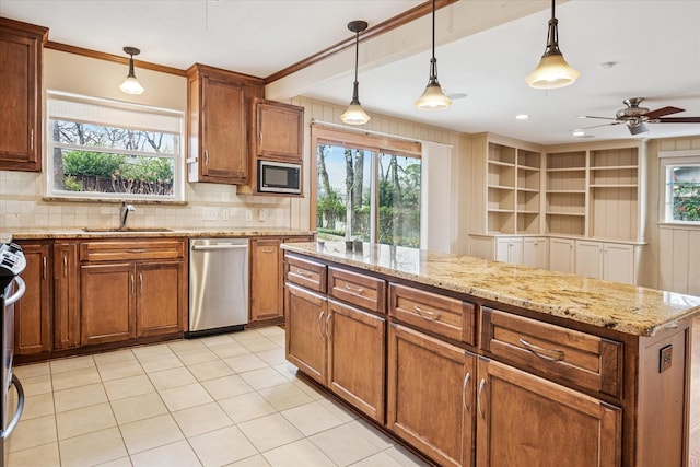 kitchen with brown cabinetry, a sink, hanging light fixtures, appliances with stainless steel finishes, and backsplash