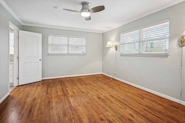 spare room featuring plenty of natural light, crown molding, and wood finished floors