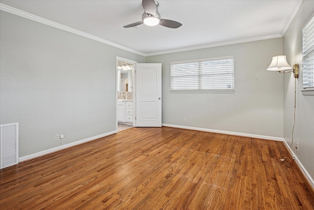 unfurnished bedroom featuring visible vents, wood finished floors, baseboards, and ornamental molding