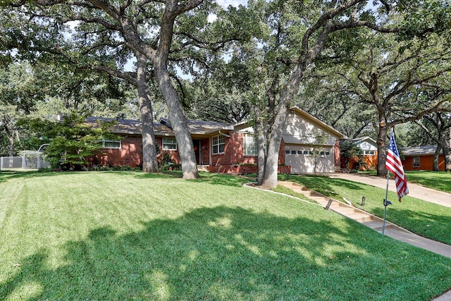 view of front facade with brick siding, an attached garage, driveway, and a front lawn