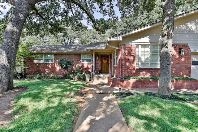 view of front of house featuring brick siding and a front yard