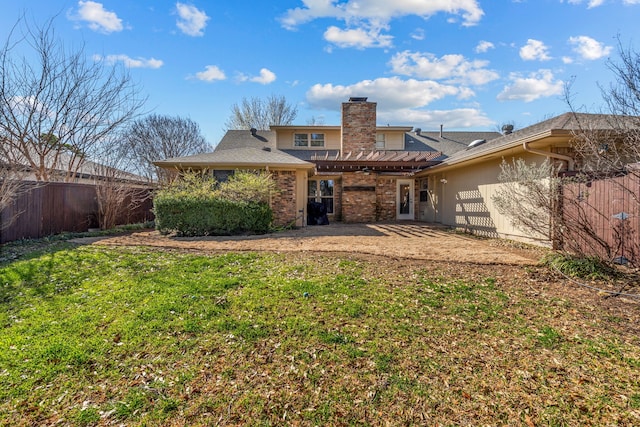 back of property with fence, a chimney, a lawn, a patio area, and brick siding