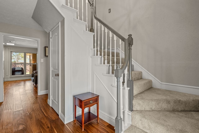 staircase with baseboards and wood finished floors