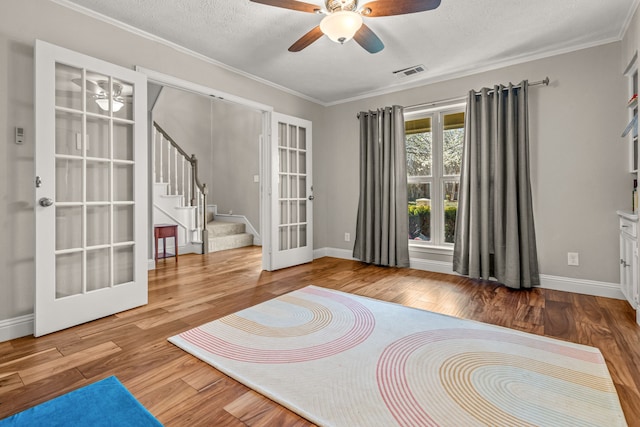 unfurnished room featuring stairs, wood finished floors, french doors, and visible vents