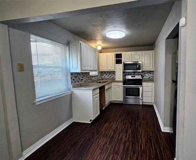 kitchen with dark wood-style floors, stainless steel appliances, backsplash, and baseboards