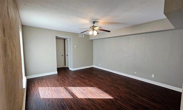 unfurnished room featuring a ceiling fan, visible vents, baseboards, and dark wood-style flooring