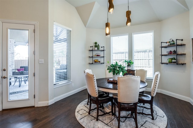 dining room with vaulted ceiling, plenty of natural light, and dark wood finished floors