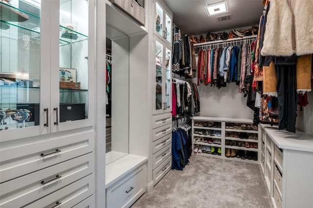 walk in closet with visible vents and light colored carpet