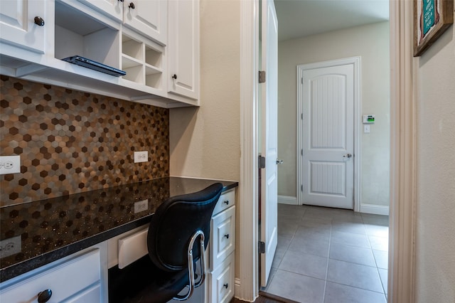 home office featuring baseboards, built in study area, and tile patterned floors