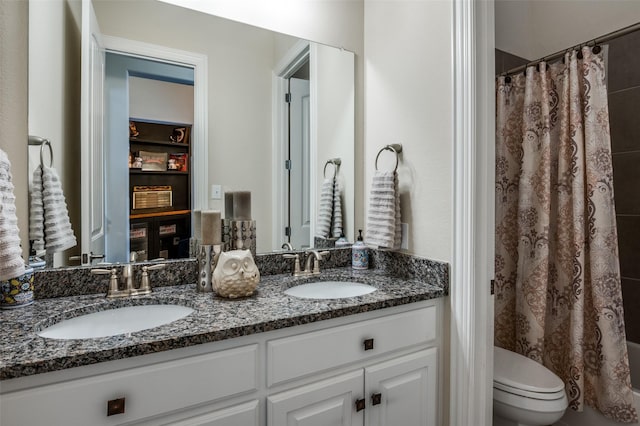 bathroom featuring toilet, double vanity, a sink, and a shower with shower curtain