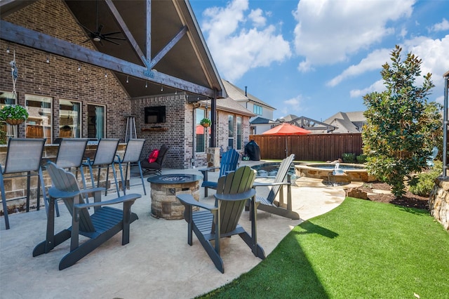 view of patio / terrace with ceiling fan, an outdoor fire pit, and fence