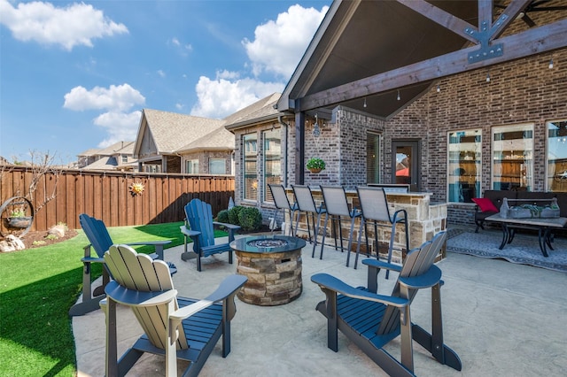 view of patio / terrace featuring fence, outdoor dry bar, and an outdoor living space with a fire pit