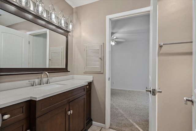 bathroom featuring baseboards, a ceiling fan, and vanity