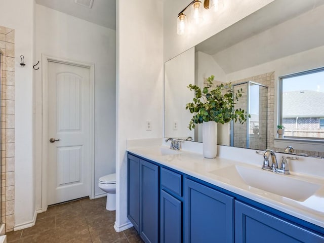 full bath with a sink, a shower stall, toilet, and double vanity