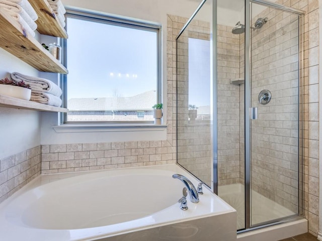 bathroom with a shower stall and a bath