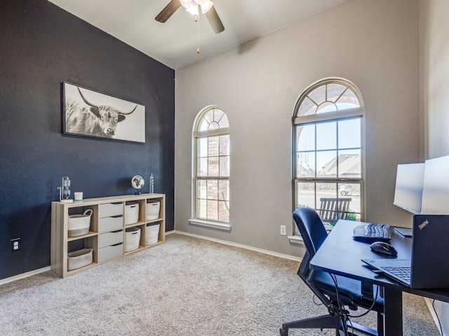 carpeted office with ceiling fan and baseboards