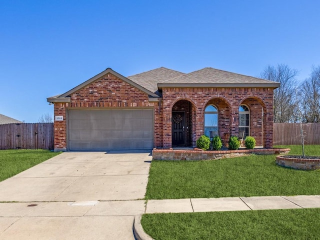 view of front of house with a garage, brick siding, a front yard, and fence