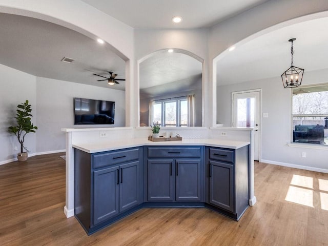 kitchen with open floor plan, light countertops, visible vents, and light wood-style flooring