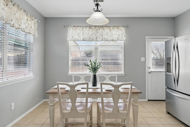 dining space with baseboards and light tile patterned flooring