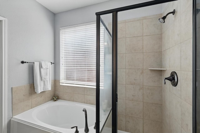 bathroom featuring a stall shower, a healthy amount of sunlight, and a bath