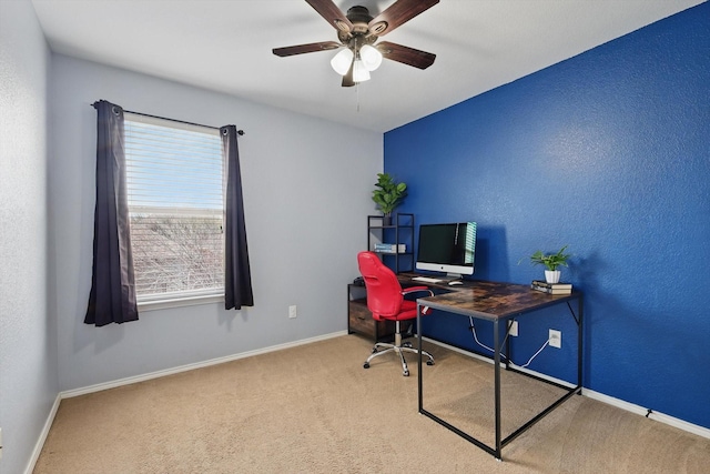 office area with carpet, a ceiling fan, and baseboards