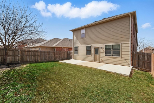 rear view of property featuring a yard, a fenced backyard, and a patio