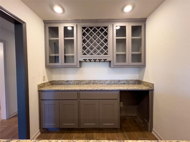 bar with a bar, wood tiled floor, and recessed lighting