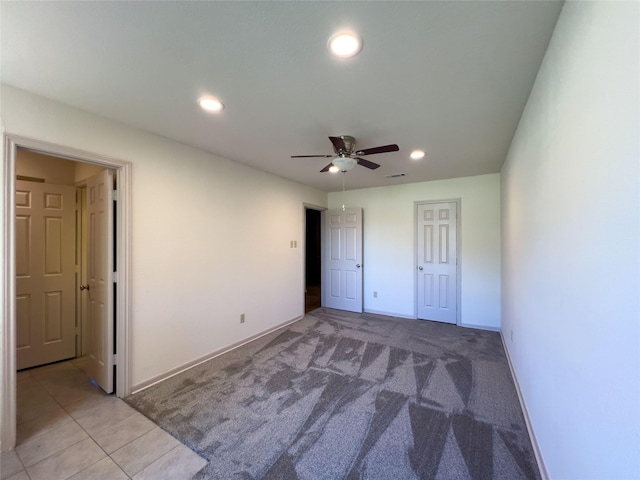 unfurnished bedroom with light carpet, baseboards, light tile patterned flooring, and recessed lighting