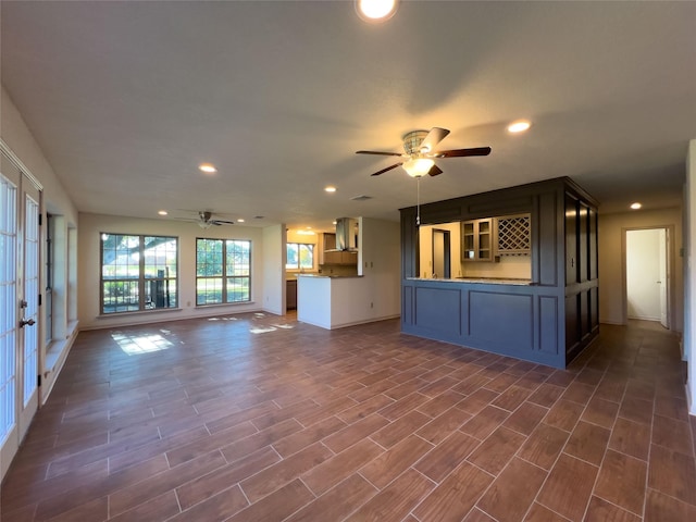 unfurnished living room with baseboards, dark wood-type flooring, a ceiling fan, and recessed lighting